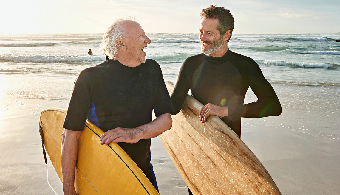 Padre e hijo en una playa con tablas de surf