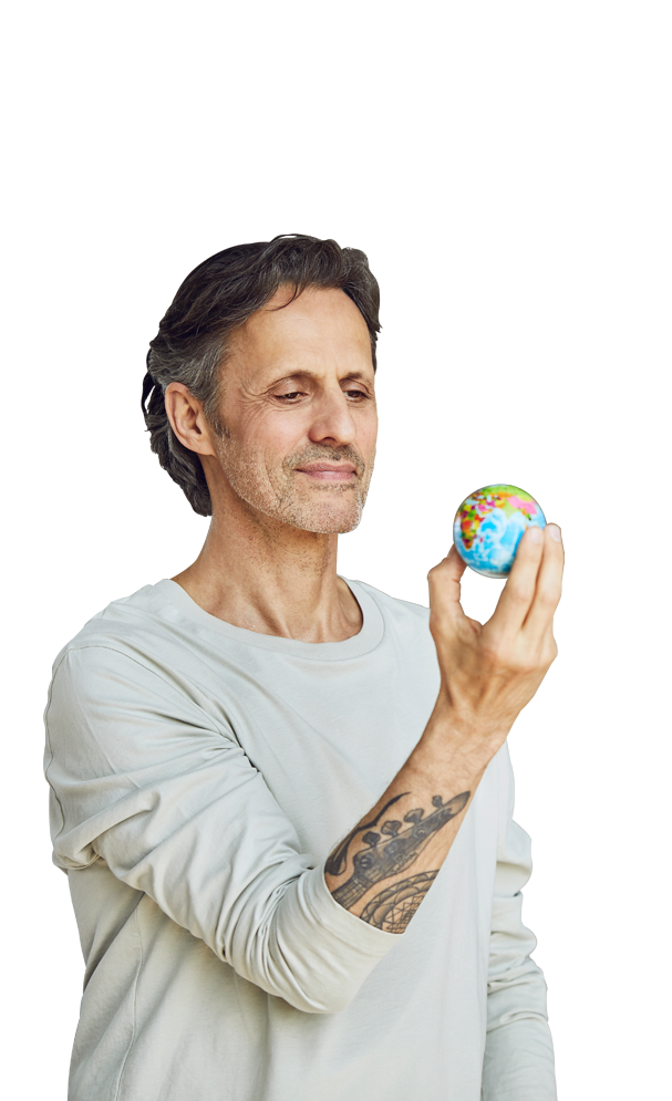 man holding a tiny globe in one hand and looking at it