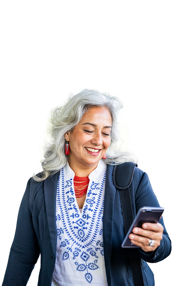 Middle aged woman smiling ad she looks down at her mobile phone in her left hand